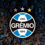 Escudo do Grêmio com torcedores ao fundo